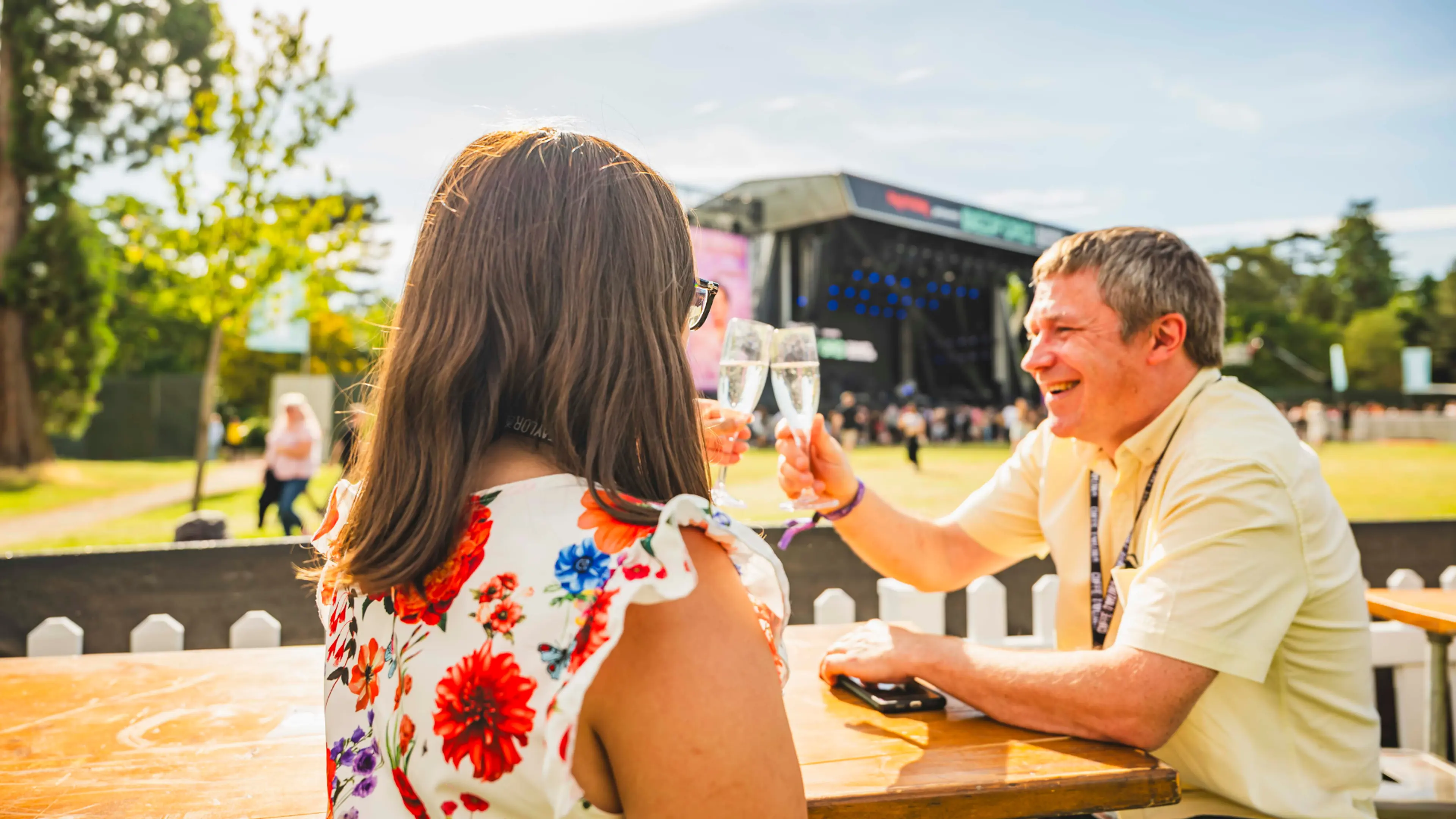 Two people sat in the terrace at Bedford Summer Sessions with a view of the stage