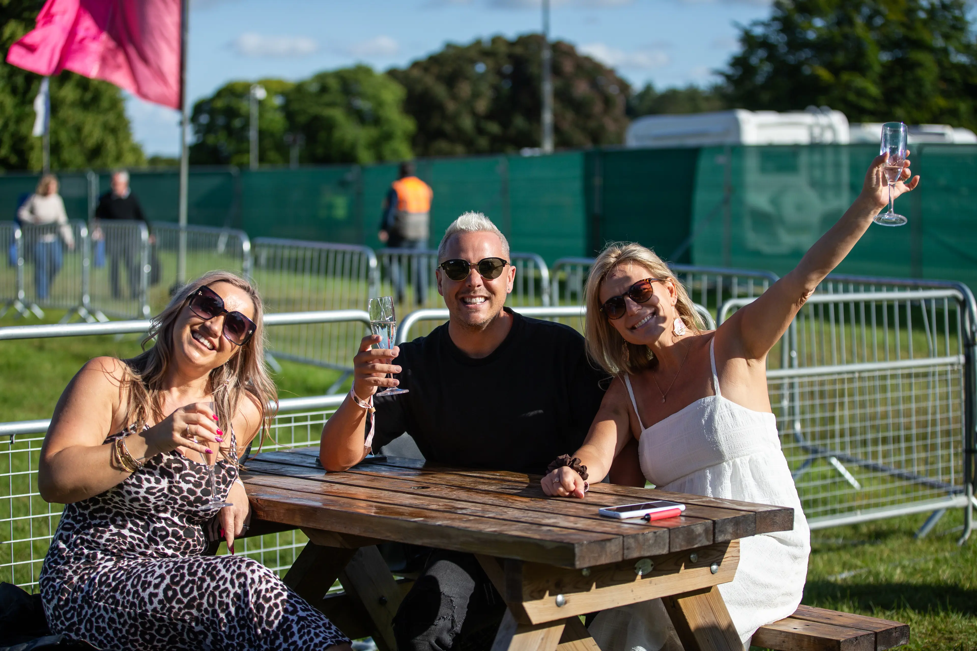 People sat in Glade VIP have a drink at a picnic bench