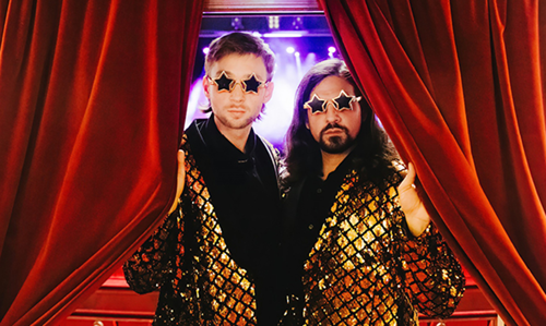 Die Comedians Siegfried und Joy beide in goldfarbenen Jackets und Stern-Sonnenbrille am roten Vorhang