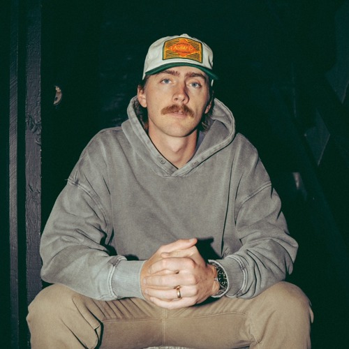 Artist Dylan Gossett wearing a grey hoodie and white coloured face cap