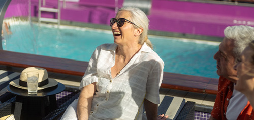 A group of passengers on deck laughing on sunbeams