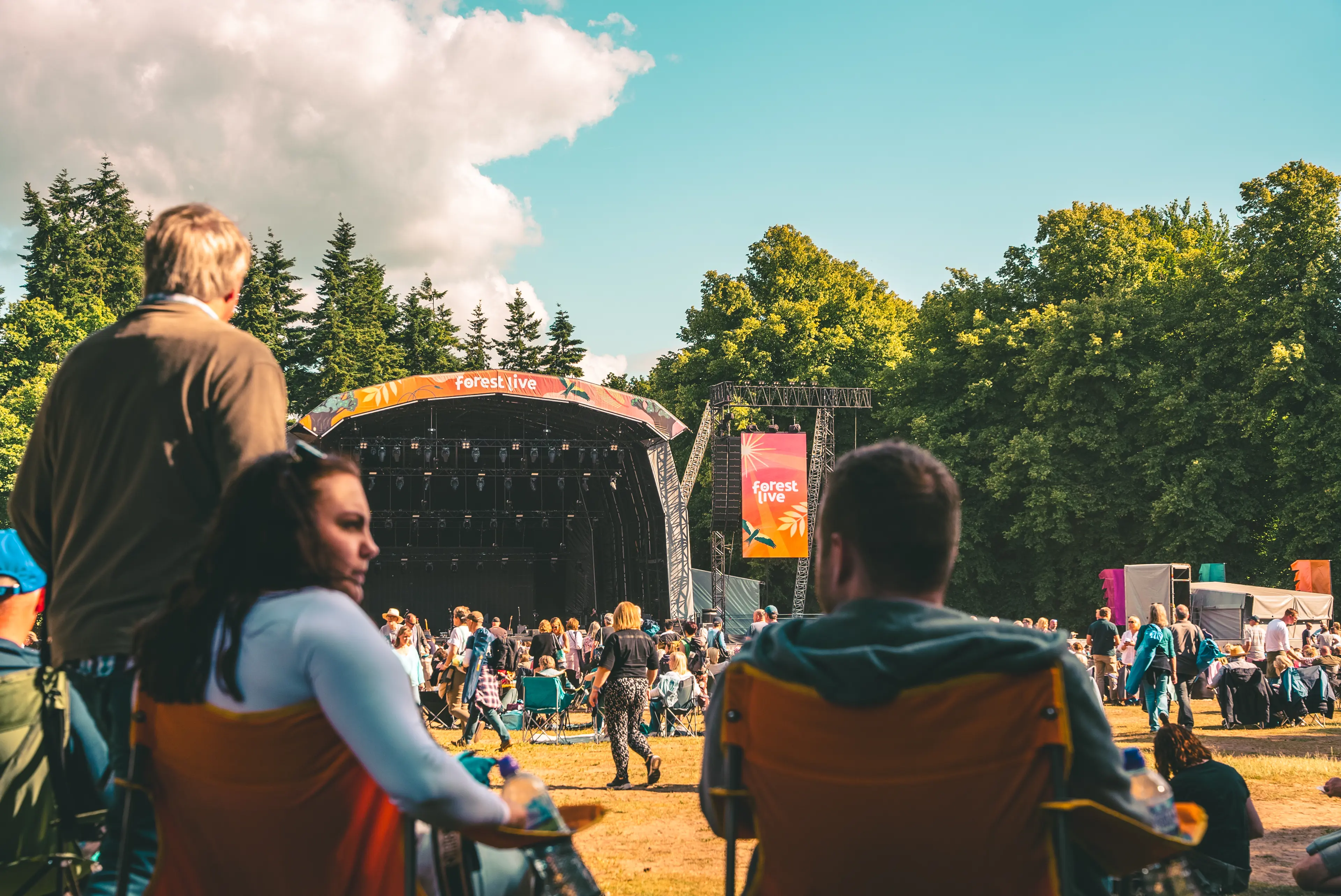 Two people sat in camp chairs in front of the stage