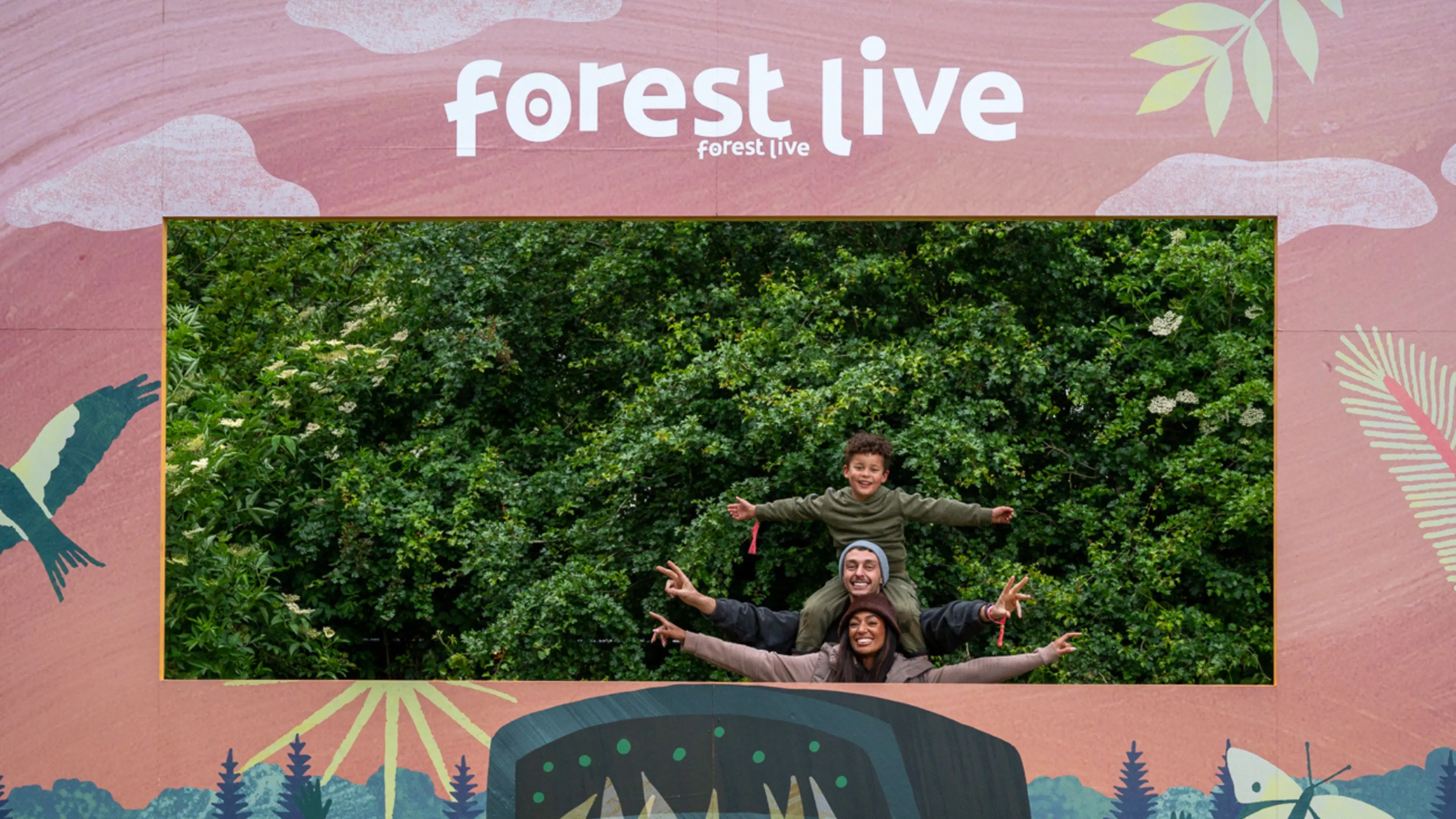 Family taking a photo against the Forest Live background